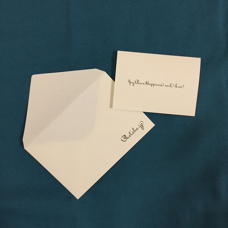 PhotoBoのロゴが入ったメッセージカードと封筒